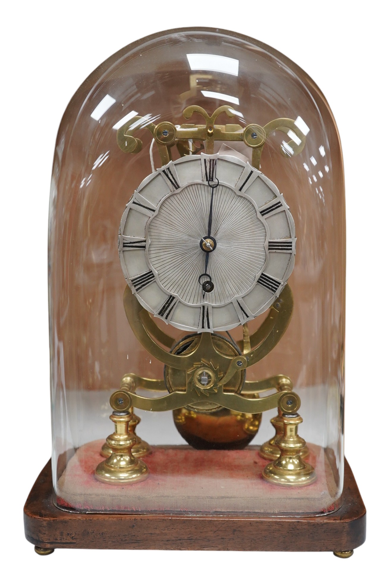 A late 19th century brass skeleton timepiece, the silvered chapter ring with Roman numerals, on a stand, under a glass dome, 37cm high. Condition - pendulum adjustment needed